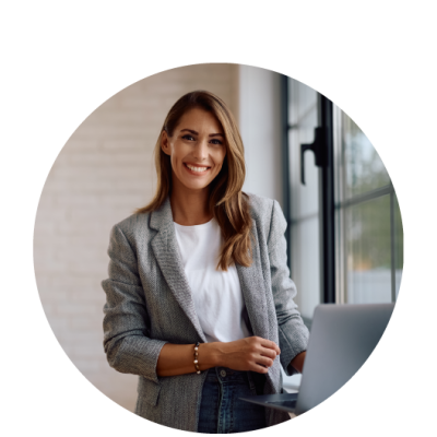 foto di una donna sui 40 anni con capelli castani lisci. è vestita con look elegante da ufficio. è sorridente e sta utilizzando il pc.